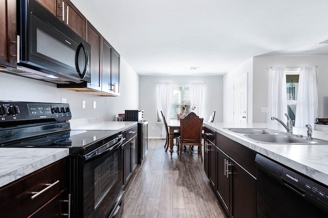 kitchen featuring dark wood-type flooring, sink, dark brown cabinetry, and black appliances