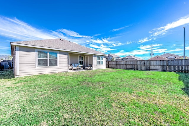 back of house featuring central AC unit, a patio area, and a yard