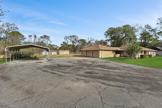 exterior space with a garage, a carport, and a lawn