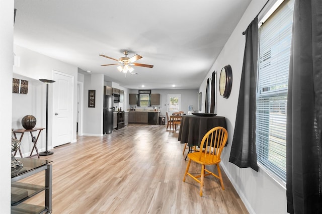 living room featuring ceiling fan and light hardwood / wood-style floors