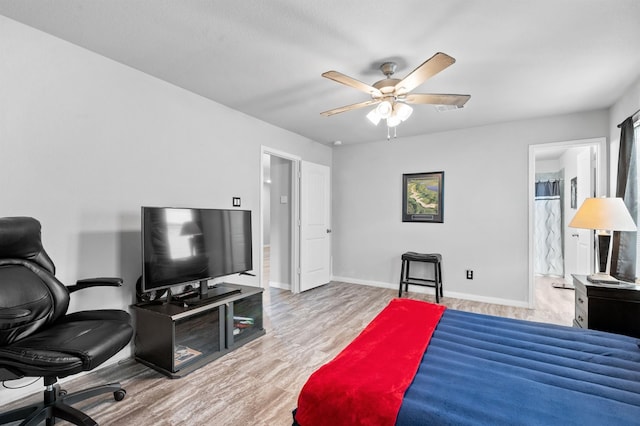 bedroom with ceiling fan, ensuite bathroom, and light hardwood / wood-style flooring