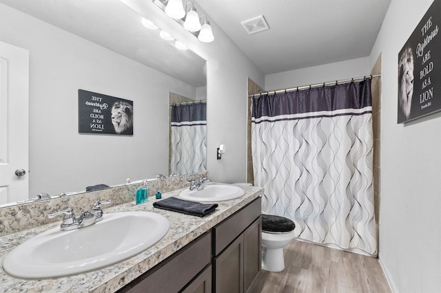 bathroom featuring toilet, a shower with curtain, hardwood / wood-style floors, and vanity