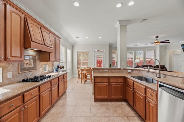 kitchen with sink, ornamental molding, plenty of natural light, and appliances with stainless steel finishes