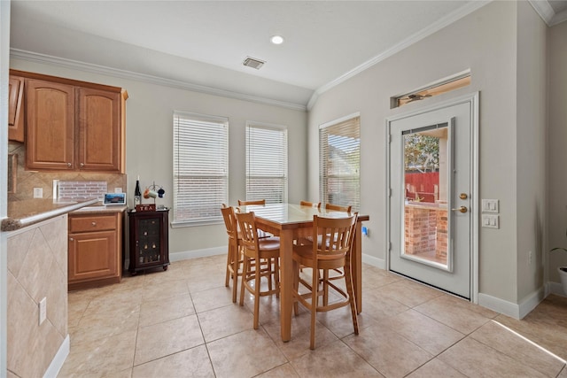 tiled dining space with vaulted ceiling and ornamental molding