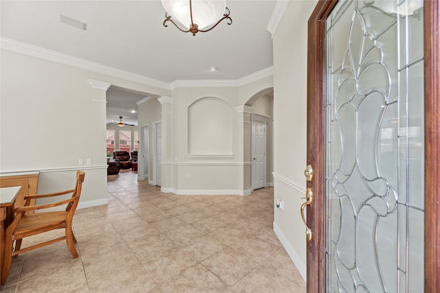 tiled entrance foyer with ceiling fan, ornamental molding, and ornate columns