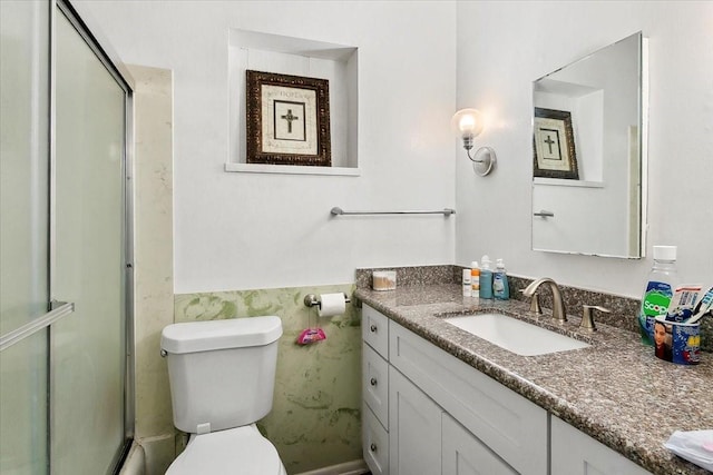 bathroom with toilet, vanity, and an enclosed shower