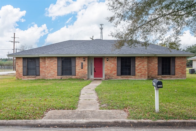 ranch-style house featuring a front lawn and central AC unit