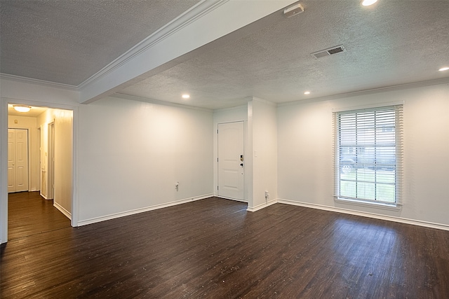 empty room with a textured ceiling, dark wood-type flooring, and ornamental molding