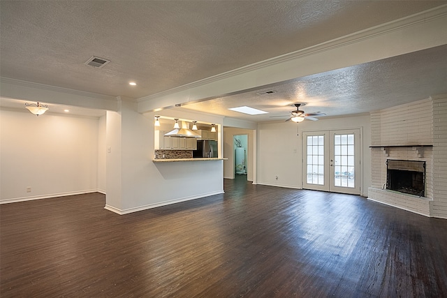 unfurnished living room featuring french doors, dark hardwood / wood-style floors, and a textured ceiling