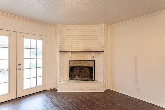 unfurnished living room featuring a fireplace, dark wood-type flooring, ornamental molding, and a textured ceiling