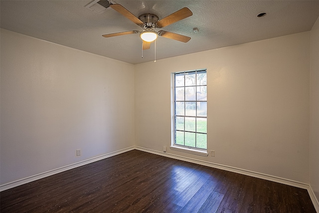 empty room featuring dark wood-type flooring, plenty of natural light, and ceiling fan