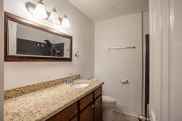 bathroom featuring toilet, a textured ceiling, tile patterned floors, and vanity