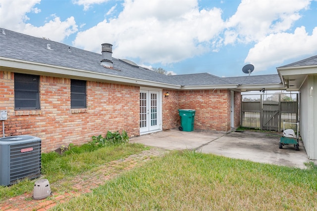 rear view of property featuring a patio area, a lawn, french doors, and central air condition unit