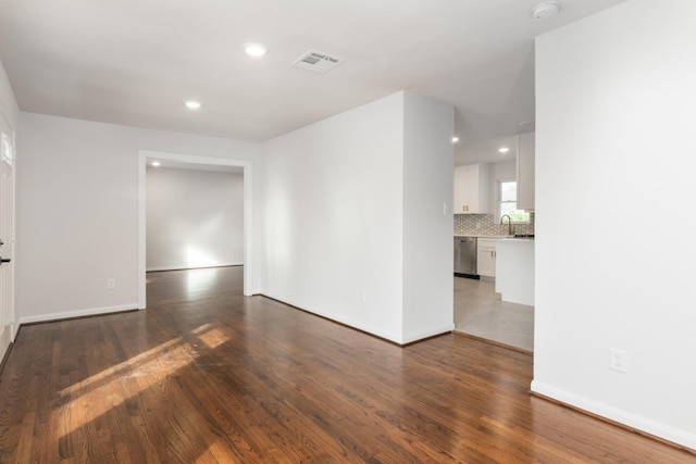 unfurnished room featuring sink and dark wood-type flooring