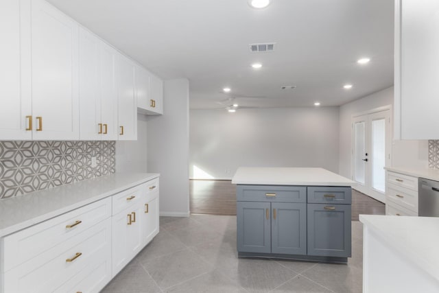 kitchen with light tile patterned flooring, gray cabinetry, white cabinetry, dishwasher, and decorative backsplash