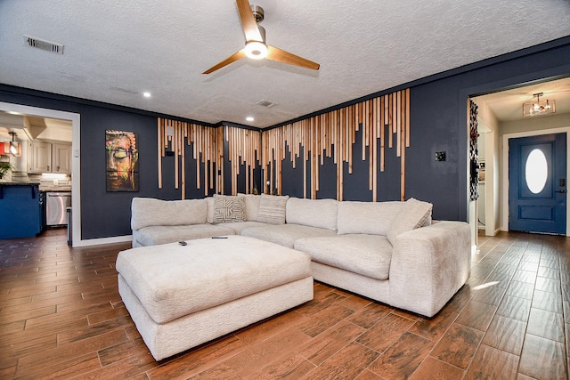 living room with ceiling fan and a textured ceiling