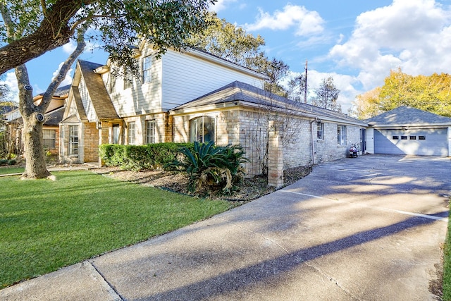 view of front of house featuring an outbuilding, a garage, and a front lawn