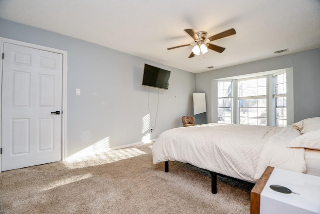 bedroom featuring a textured ceiling, ceiling fan, and carpet flooring