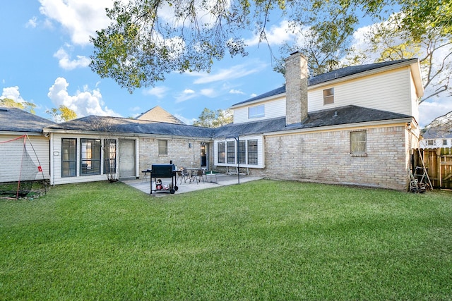 rear view of house with a lawn and a patio