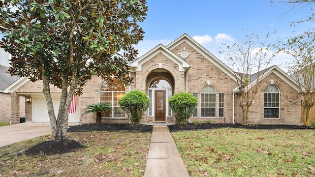 view of property featuring a garage and a front lawn