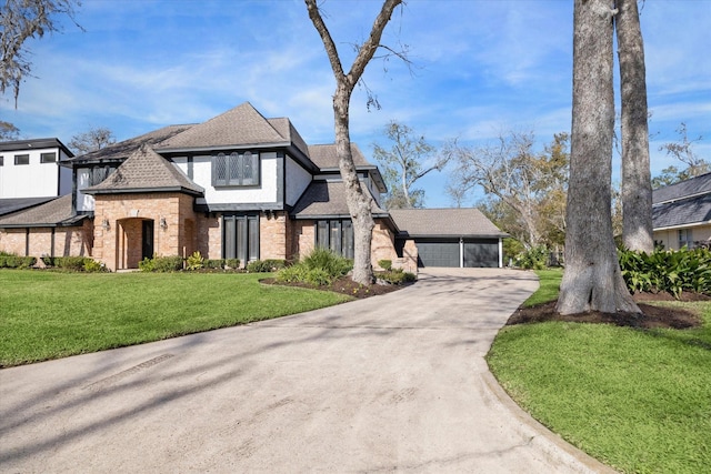 tudor house featuring a garage and a front yard