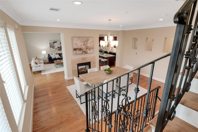 stairway with crown molding, a chandelier, and hardwood / wood-style flooring