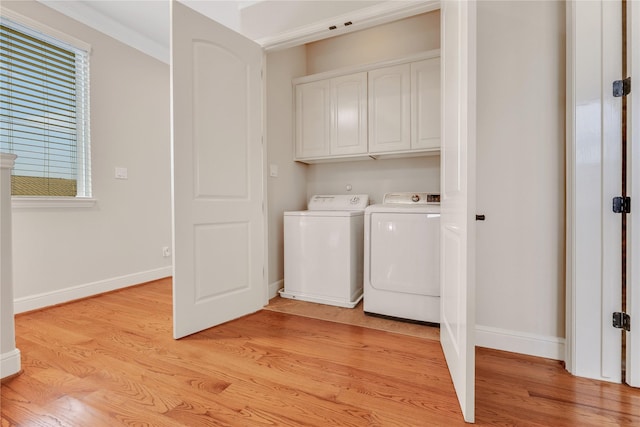 washroom with cabinets, washing machine and clothes dryer, plenty of natural light, and light wood-type flooring