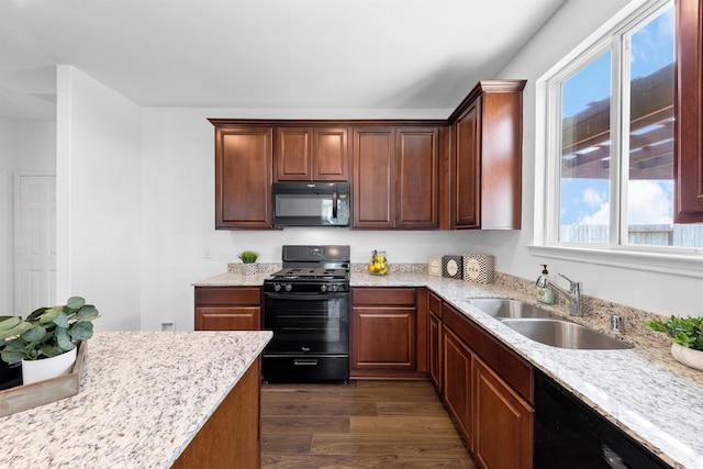 kitchen with dark wood-type flooring, sink, light stone counters, and black appliances