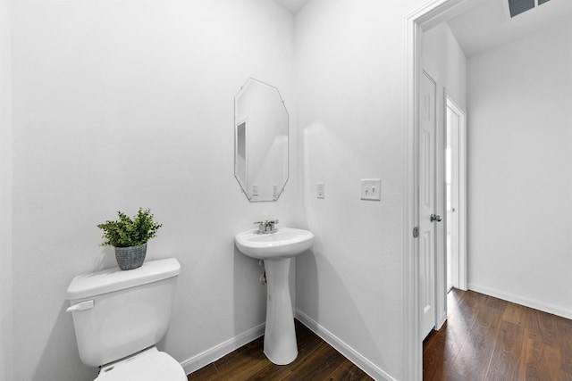 bathroom with toilet, hardwood / wood-style floors, and sink