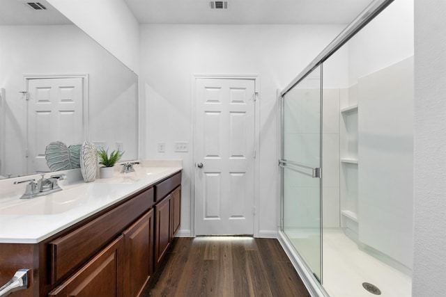 bathroom with a shower with shower door, wood-type flooring, and vanity