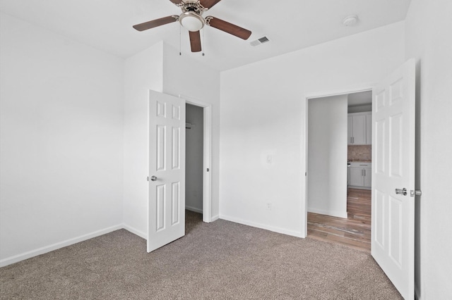 unfurnished bedroom with ceiling fan and carpet