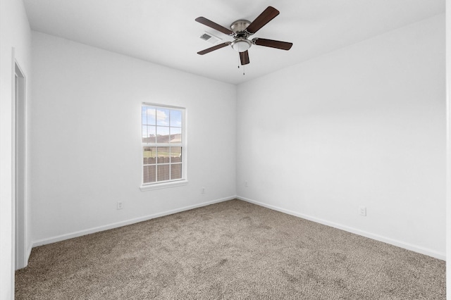 empty room featuring ceiling fan and carpet