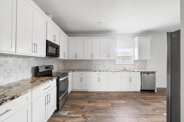 kitchen featuring white cabinetry, appliances with stainless steel finishes, dark wood-type flooring, light stone counters, and sink