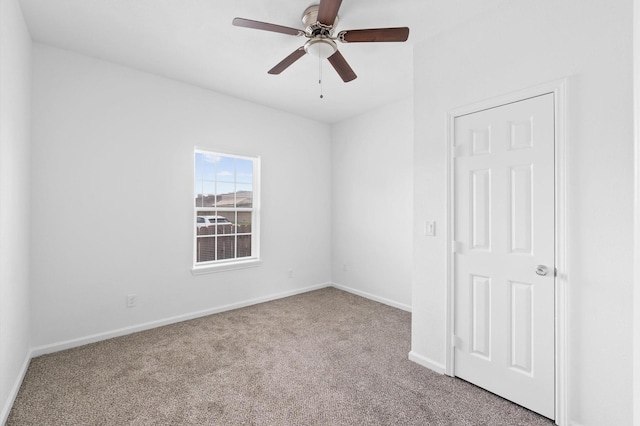 carpeted spare room with ceiling fan