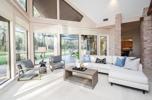 carpeted living room featuring high vaulted ceiling