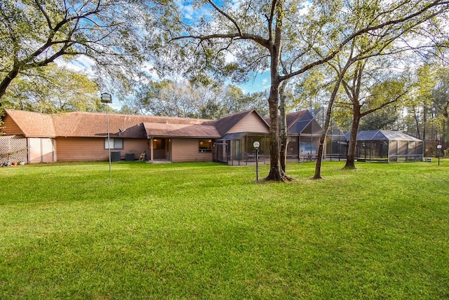 exterior space with a lanai and a lawn