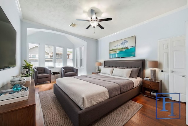 bedroom with ceiling fan, ornamental molding, and dark hardwood / wood-style floors