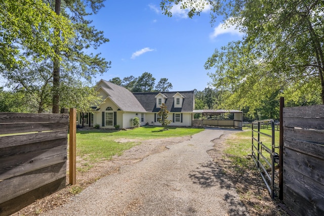 cape cod house featuring a front lawn and a carport