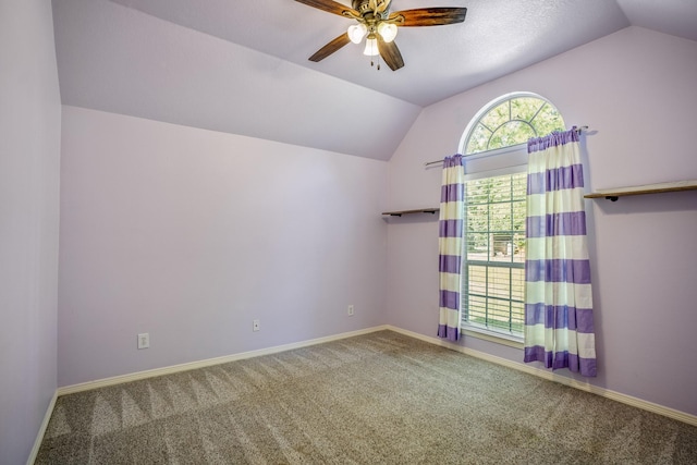 carpeted empty room featuring ceiling fan and vaulted ceiling