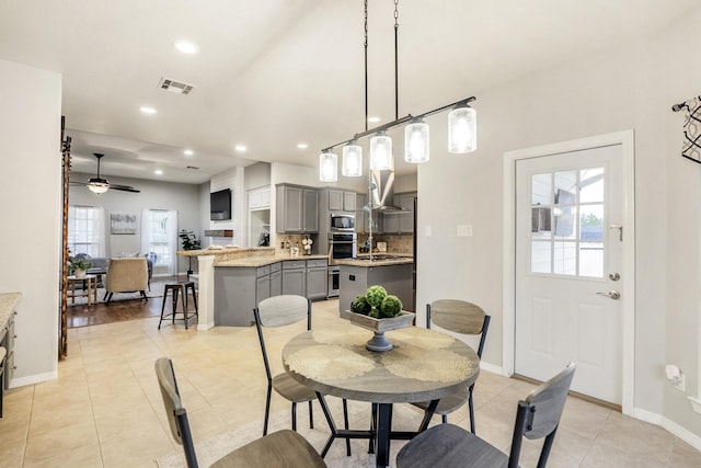 dining space featuring ceiling fan and light tile patterned floors