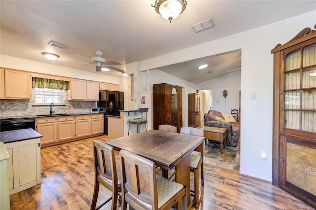 interior space featuring black appliances, lofted ceiling, sink, hardwood / wood-style flooring, and ceiling fan