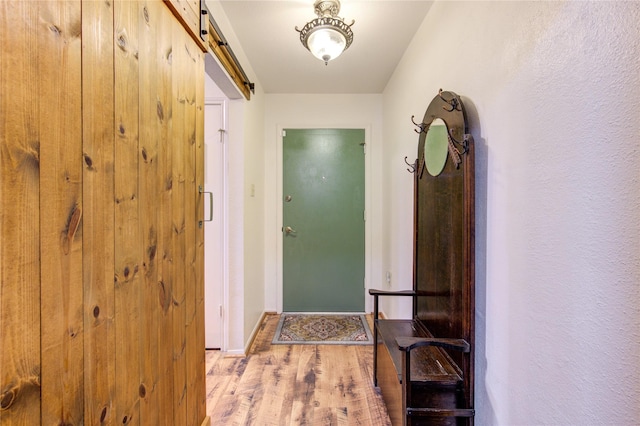 doorway with light hardwood / wood-style floors and a barn door