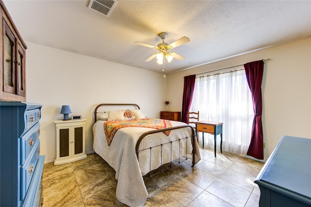 bedroom with a textured ceiling and ceiling fan