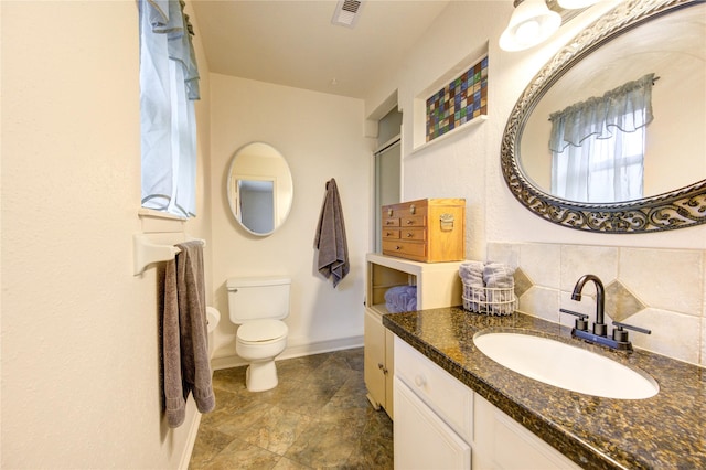 bathroom featuring tasteful backsplash, vanity, and toilet