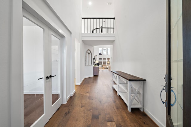 interior space with a high ceiling, dark hardwood / wood-style floors, and french doors