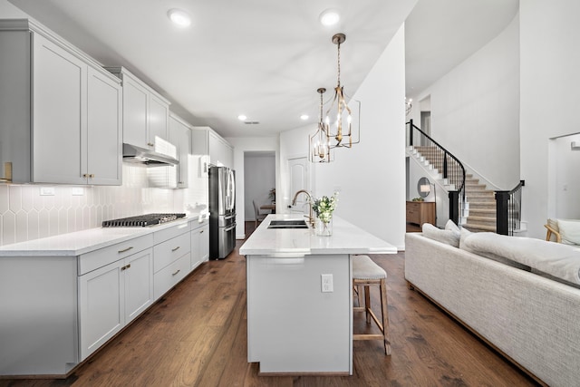 kitchen featuring pendant lighting, sink, appliances with stainless steel finishes, white cabinetry, and decorative backsplash