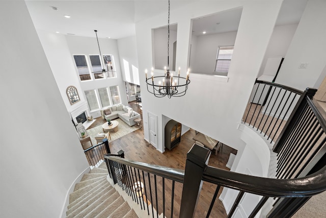 stairway featuring a high ceiling and an inviting chandelier