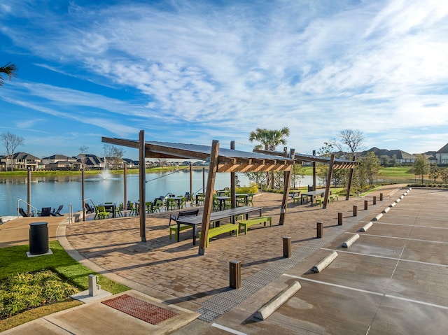 surrounding community featuring a water view and a pergola