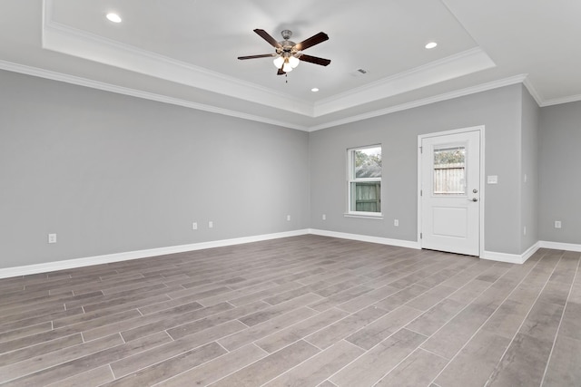 unfurnished living room with a raised ceiling, ceiling fan, crown molding, and light hardwood / wood-style flooring