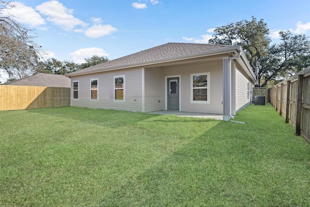 rear view of house with a lawn and central AC